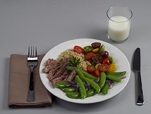 Plato de la cena con porciones equilibradas de carne, vegetales y almidones, y un vaso de leche.