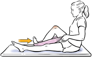 Mujer sentada sobre un tapete de ejercicios usando una toalla alrededor del pie para realizar un ejercicio de deslizamiento de talón.