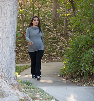 Mujer embarazada caminando al aire libre.